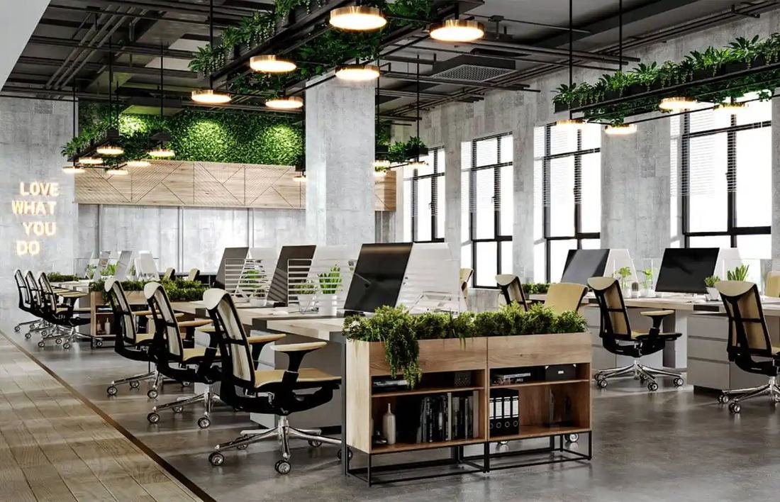 Open-plan office with linear workstations, pendant lighting and a green living wall
